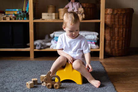 girl, potty training, playing with his toys on pottyの写真素材