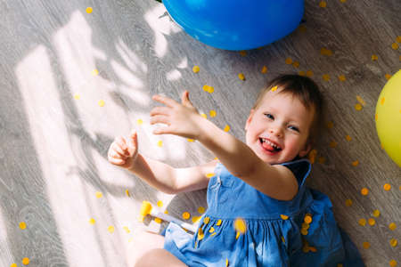 A small child watches cartoons on a tablet while sitting on the couch at home alone.の写真素材