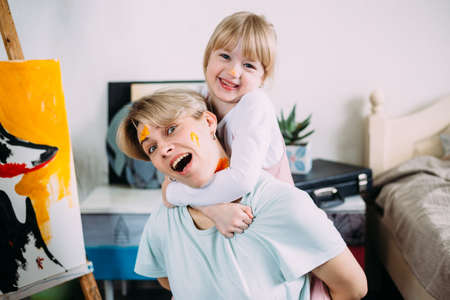beautiful mother artist and her child paint picture at home with acrylic paints.の写真素材