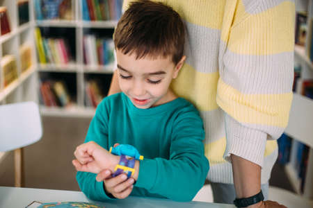 Mom gives her son his first watch. Learning to determine the time by the clock.