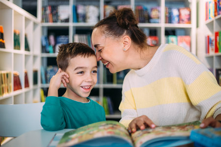 Mom and her little child, the preschooler son, read together childrens booksの写真素材