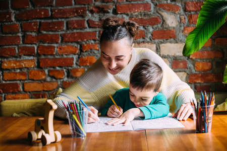 Child and adult are drawing a coloring book.の写真素材