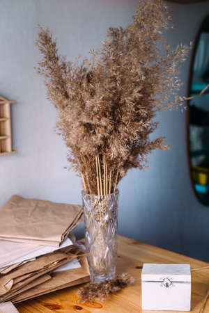 Dry reeds, reeds in vase, craft paper, wood and neutral colors in still lifeの写真素材