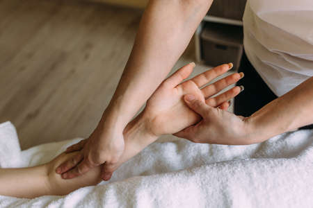 The masseur gives massage to female hand at the spa.の写真素材