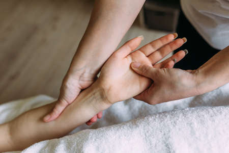 The masseur gives massage to female hand at the spa.の写真素材