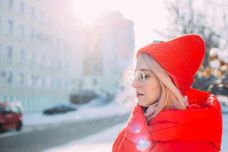 Young stylish blonde woman on the street has fun, posing in snowy, frostyの写真素材