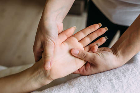 The masseur gives massage to female hand at the spa.の写真素材