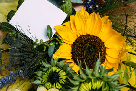 Fresh cut sunflowers in bouquet and card with envelope with copy spaceの写真素材