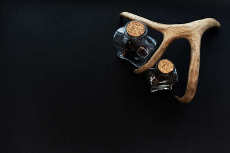 Two magic alchemy potion bottles on black paper background. Mockup, copy space.の写真素材