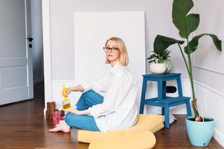 Young woman artist is painting at home in a creative studio setting.