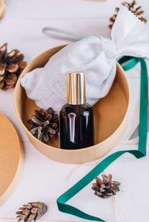 A mockup of a glass bottle with a cosmetic product as a Christmas present.の写真素材