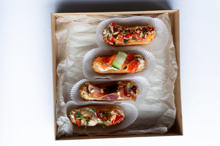 Eclairs with salmon, fresh vegetables and herbs, gourmet snacks.