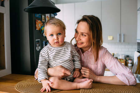 Mom plays at home with a small child on the couch, have fun.の写真素材