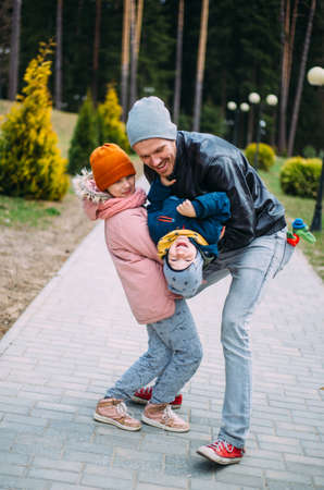 Father and two children walk in nature in autumn, spend time together, have fun.の写真素材