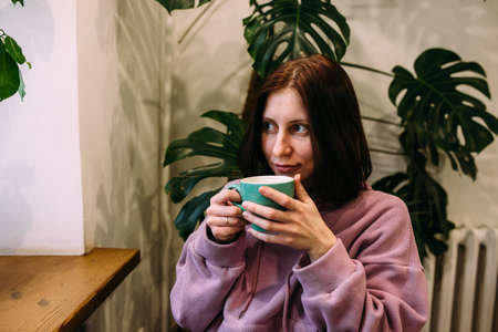 Young woman is drinking coffee in coffee shop. Time for yourself.