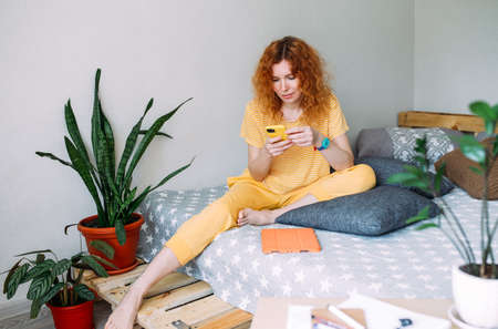 Young woman talking on smartphone from home on video callの写真素材