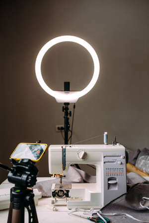 Shooting video of the sewing process, workshop on clothing design on smartphone
