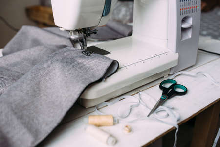 Sewing machine, accessories and fabric. Cozy creative sewing process at home