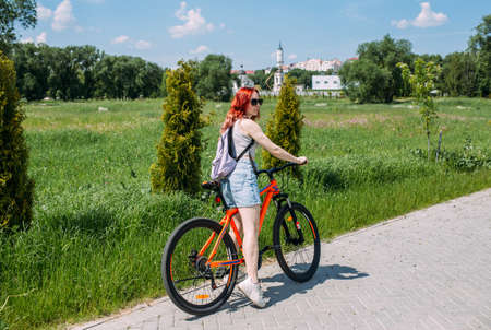 Young woman in the city rides bike and leads an active lifestyle doing sportsの写真素材