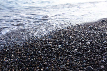 Seashore with pebbles and stones in the evening at sunset