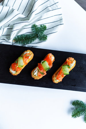 Eclairs with salmon, fresh vegetables and herbs, gourmet snacks.