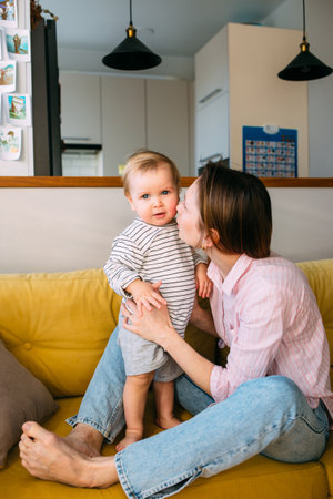 Mom plays at home with a small child on the couch, have fun.