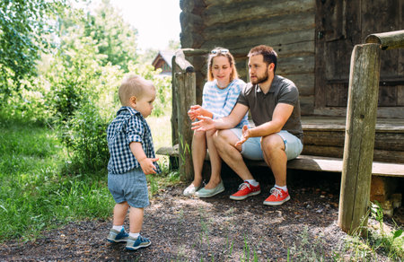 Mom, dad and little son spend time together in the summer outdoorsの写真素材