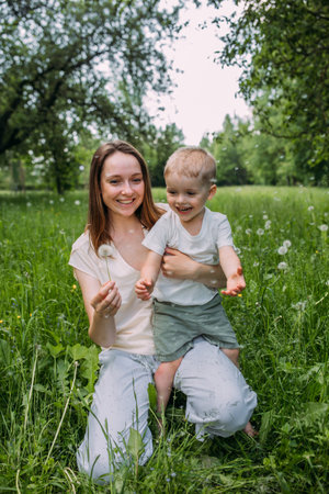 Young woman mom and son play in nature, spend time together and have funの写真素材