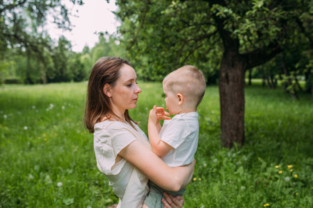 Young woman mom and son play in nature, spend time together and have funの写真素材