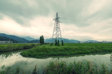 Power tower beside riverの写真素材