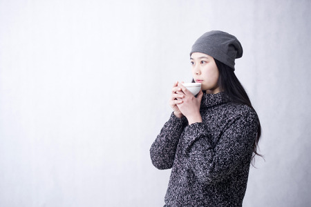 Asian Chinese girl drinking coffeeの写真素材