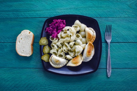 Homemade vegetarian food, pasta with seasoning, dumplings with potatoes and mushrooms pickled cucumber beetroot and a slice of white bread,  vetch, bon appetitの写真素材