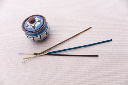 Different kinds of incense and pot on a light beige backgroundの写真素材