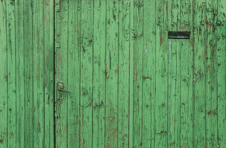 Old door disguised as a green fence with a mailbox.の写真素材