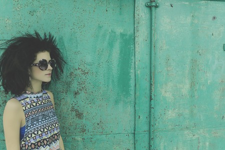 Laughing African young woman with an afro hairstyle wearing sunglasses and pastel stylizationの写真素材