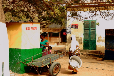 GOREE,SENEGAL-APRIL 13, 2014  Local woman buy some bread in the village bakery on April 13, 2014 in Senegal のeditorial素材