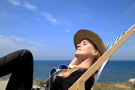 Blonde woman on deck chair-Franceの写真素材