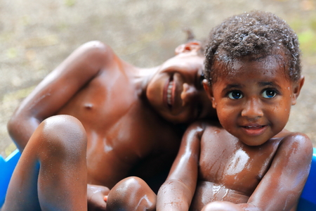 EPI,VANUATU-OCTOBER 4, 2014: Brothers share a bathroom with a laugh in front of the photographer on October 4, in Lamen Bay-Vanuatu.のeditorial素材