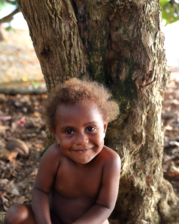 PANGI,VANUATU-OCTOBER 12, 2014: Little girl accompanies her mother who sells fruit at a stall near the airport on October 12, in Pangi-Vanuatu.のeditorial素材