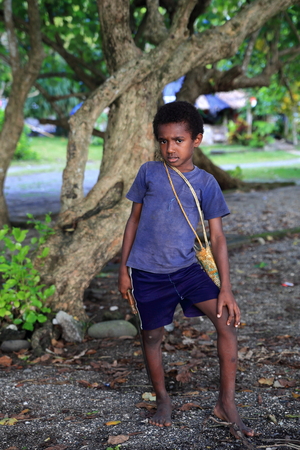 PANGI,VANUATU-OCTOBER 14, 2014: Young locale goes to school with traditional machete to cross the jungle  on October 14, in Pentecost-Vanuatu.のeditorial素材