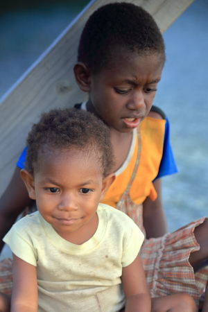 PANGI,VANUATU-OCTOBER 14, 2014: Native boy takes care of his brother while their parents work in a local business on October 14, in Pentecostes-Vanuatu.のeditorial素材