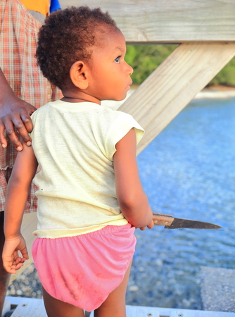PANGI,VANUATU-OCTOBER 14, 2014:Baby learns to handle the indispensable machete in everyday life in Vanuatu on October 14, in Pentecostes-Vanuatu.のeditorial素材