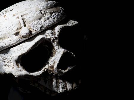 menacing white human skull on a black background close-up. Top view. Half frame free for writing textの写真素材