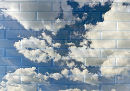 A cloudy blue sky in a brick wall.の写真素材