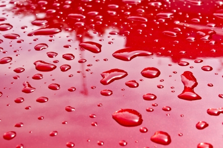 Red car after rain  Water drops collect on top of metal surface の写真素材