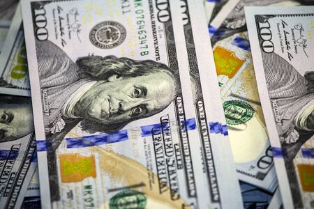 Close-up portrait of Franklin with hundred dollar bills on a stack of dollars