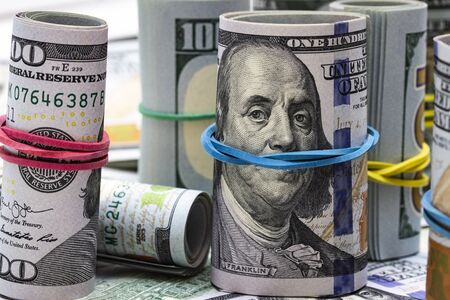 One hundred dollar bills bundles and Franklin portrait macro close-up background.
