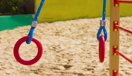 red gymnastics rings children's Playground ,open air on a sand platform
