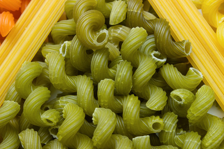 green colored macaroni and spaghetti, uncooked, a scattering angle of spaghettiの写真素材