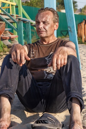 Homeless Man. Poor people in the childrens Playground at sunseの写真素材